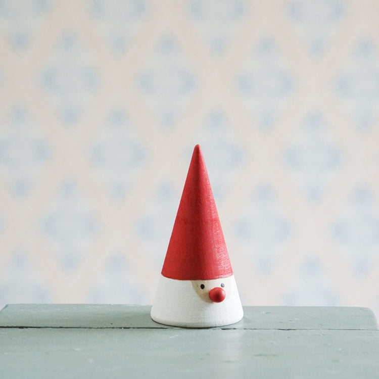 Wichtel in Kegelform mit angemalter Mütze, Bart, Gesicht, die Nase ist eine rote Kugel