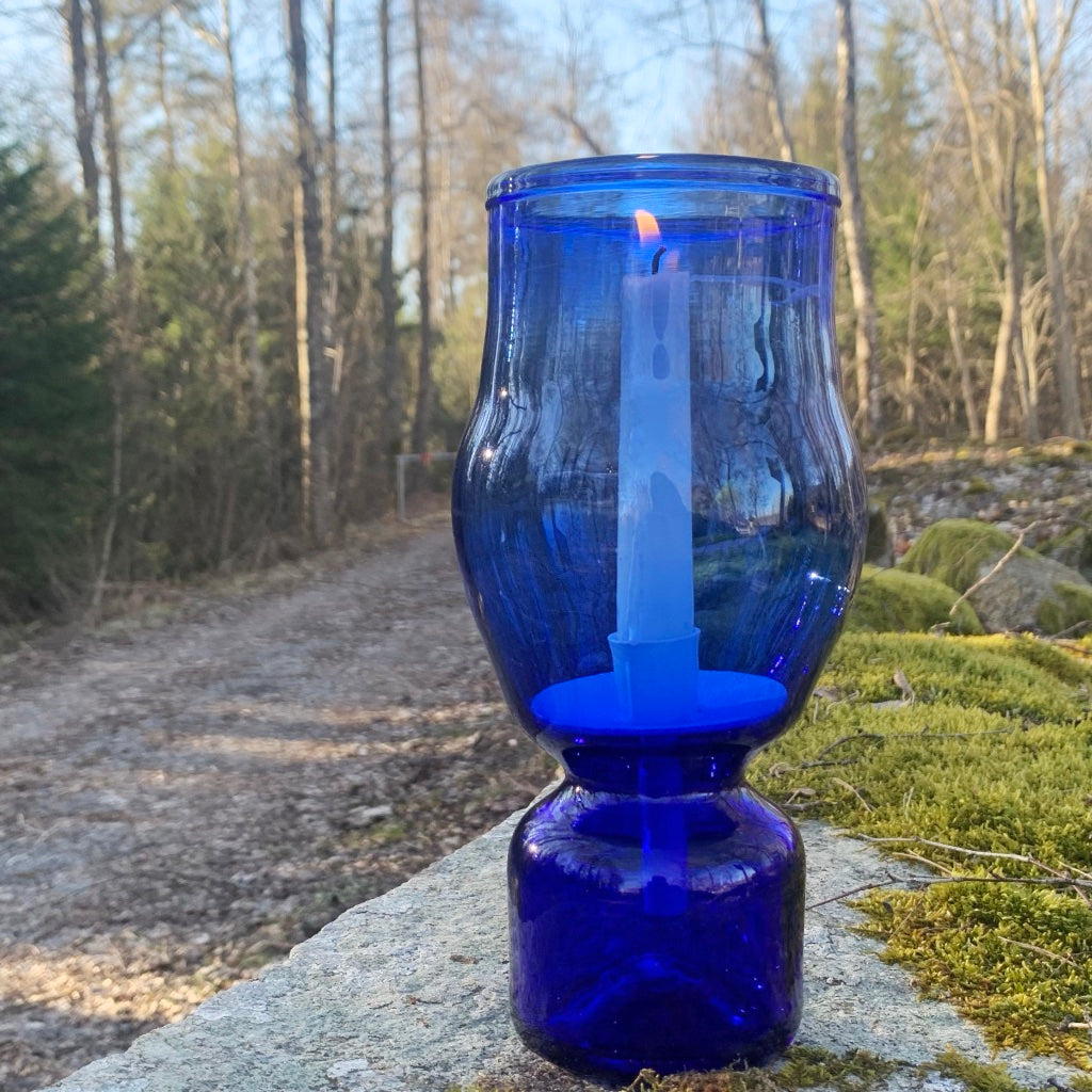 blaues Windlicht aus Glas im schwedischen Wald
