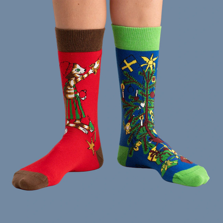 eine rote, eine blaue Socke mit Motiv Findus schmückt den Weihnachtsbaum