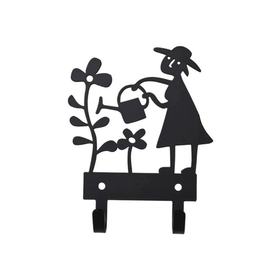 Haken aus Metall in schwarz mit Gärtnerin, die eine große Blume gießt