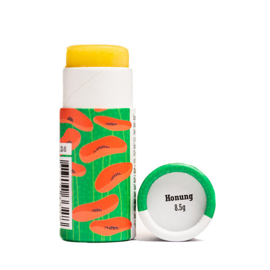 offene, grüne Verpackung mit aufgedruckten Mohnblüten des Lippenbalsams Honig von Gusatf und Linnea