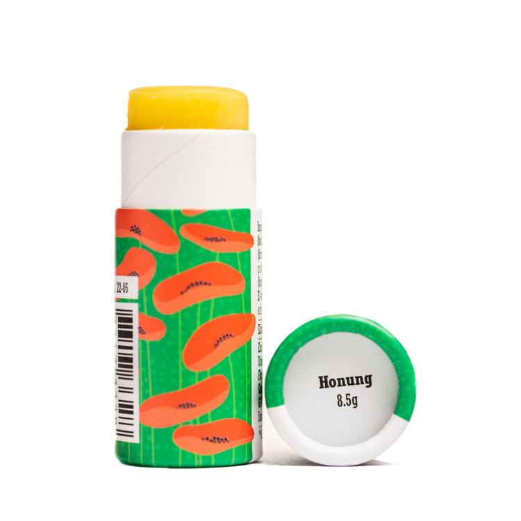 offene, grüne Verpackung mit aufgedruckten Mohnblüten des Lippenbalsams Honig von Gusatf und Linnea