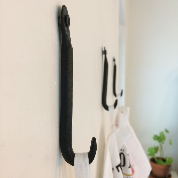 3 Haken aus Schmiedeeisen an Wand mit Geschirrtüchern