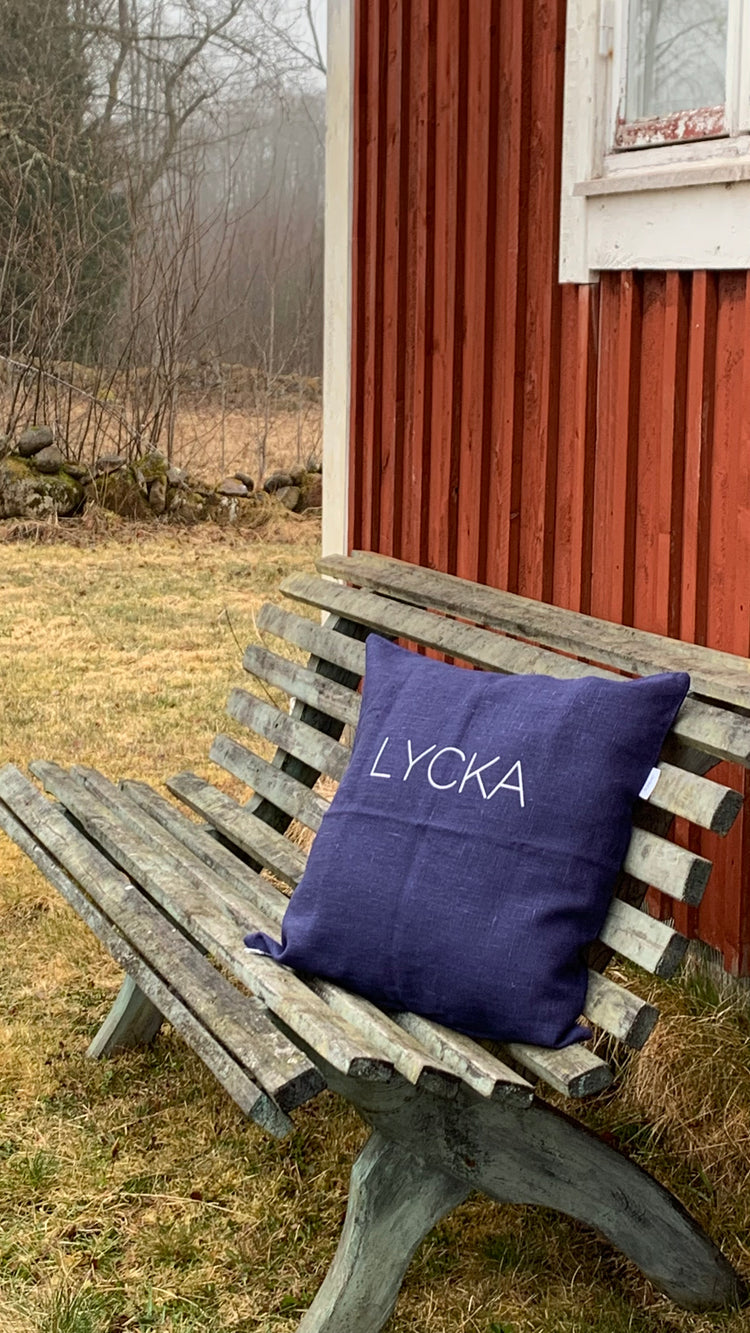 Kissen Lycka Leinen blau vor Schwedenhaus