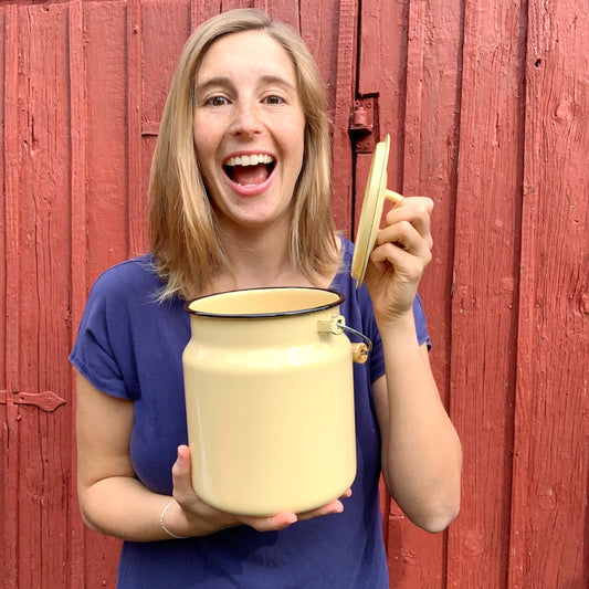 Marie vor Schwedenhaus mit Milchkanne Emil in gelb