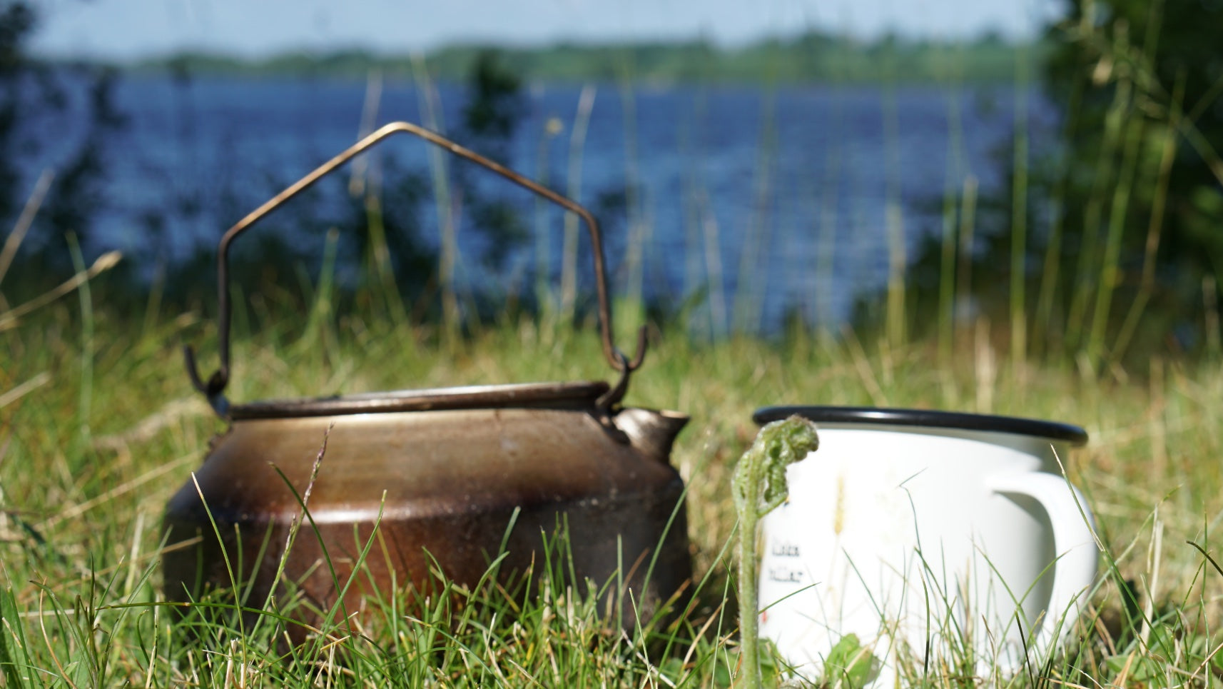 Camper Wasserkessel und Emailletasse am See in Schweden