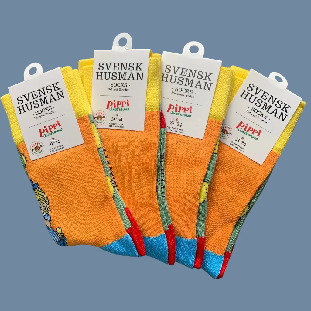 4 Paar Kinder Socken Pippi bäckt Plinsen vor mysblauem Hintergrund