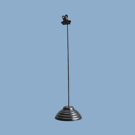 Fotohalter aus Metall in Schwarz vor blauem Hintergrund