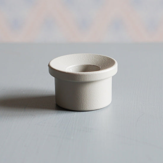 Kerzenhalter Adapter aus Metall in Farbe kalk auf Tisch vor schwedischer Tapete