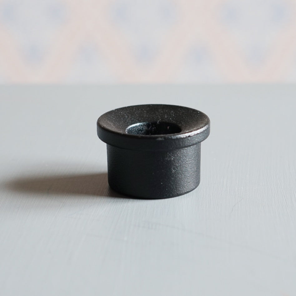 Kerzenhalter Adapter aus Metall in Farbe schwarz auf Tisch vor schwedischer Tapete
