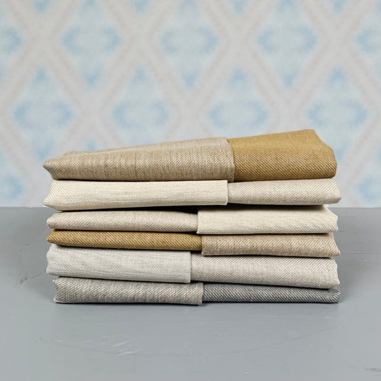 Badetücher Spa aus Leinen umbra und schwarz als Stapel vor Tapete im Laden