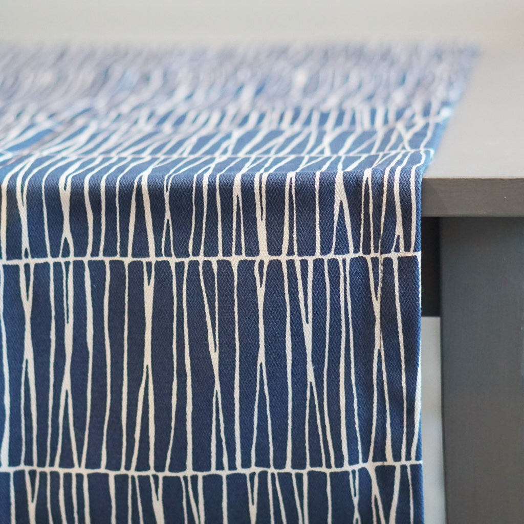 Tischläufer Barr aus Baumwolle in blau auf Tisch