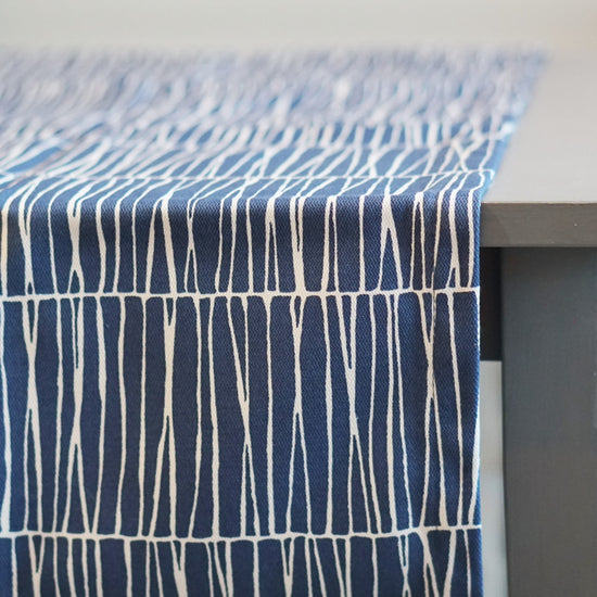 Tischläufer Barr aus Baumwolle in blau auf Tisch