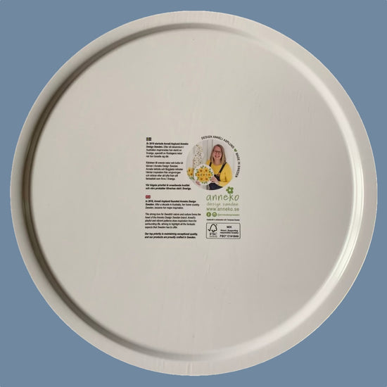 Rücksseite des Runden Holztabletts mit Bienen it Info über Anneko Design auf Schwedisch und Englisch