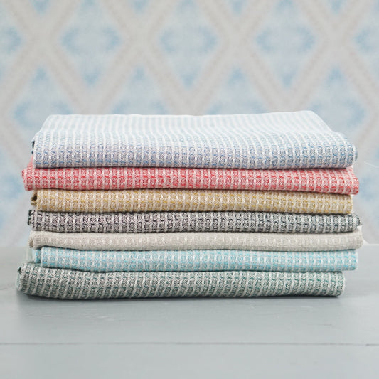 Badetuch Bubbel aus Leinen ohne Banderole im Stapel vor Schwedentapete im Laden