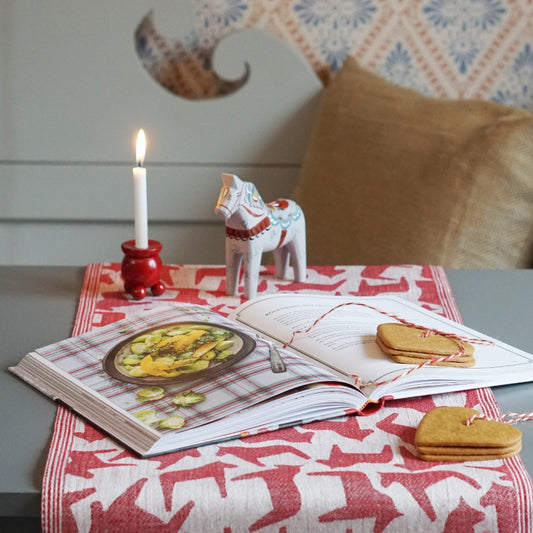 Dalapferd Tischlufer Leinen rot auf Tisch mit ugelleuchter und Dalapferd Holz grau