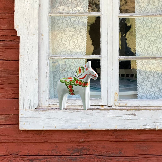 Dalapferd Original weiß 13 cm auf dem Fensterbrett an einem schwedischen Haus
