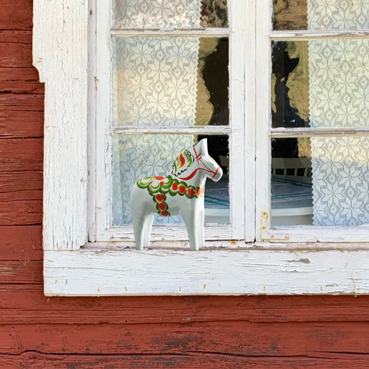 Dalapferd Original weiß 13 cm auf dem Fensterbrett an einem schwedischen Haus