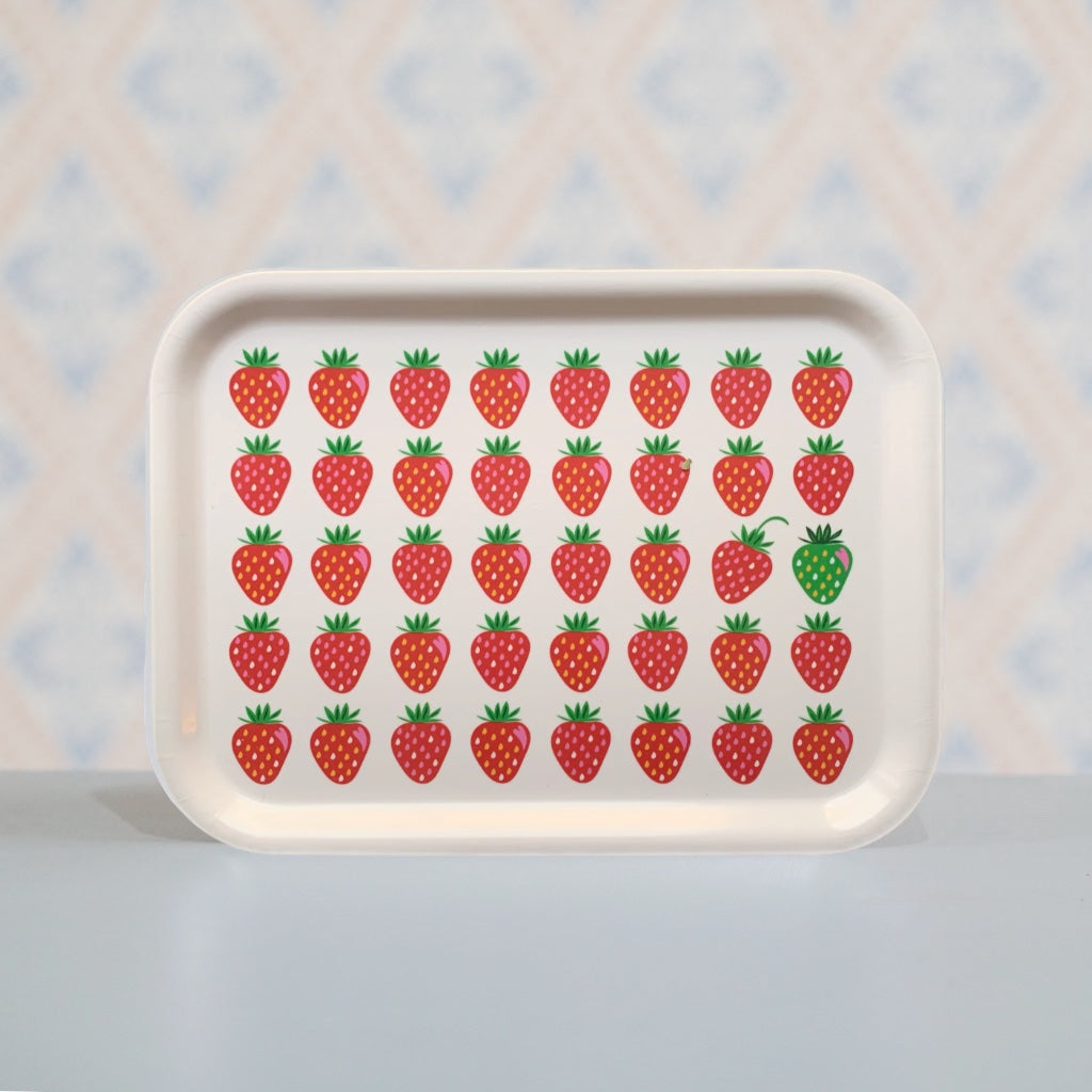 Holztablett mit fünf Reihen roter Erdbeere, eine davon ist grün