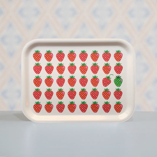 Holztablett mit fünf Reihen roter Erdbeere, eine davon ist grün