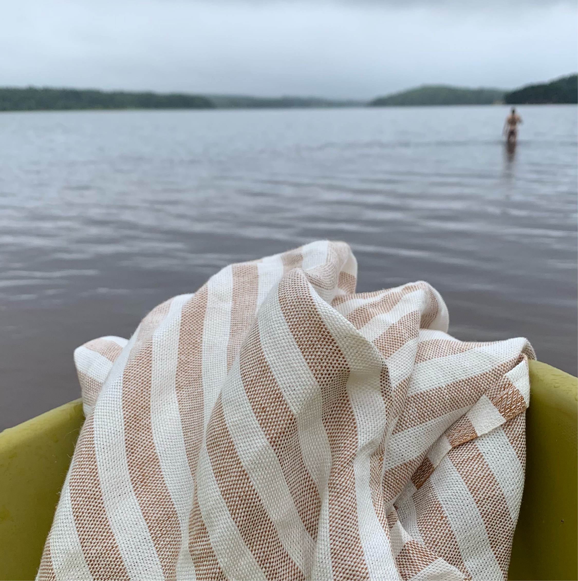 Badetuch Regnbåge  aus Leinen in ziegelrot/sand auf Boot am See