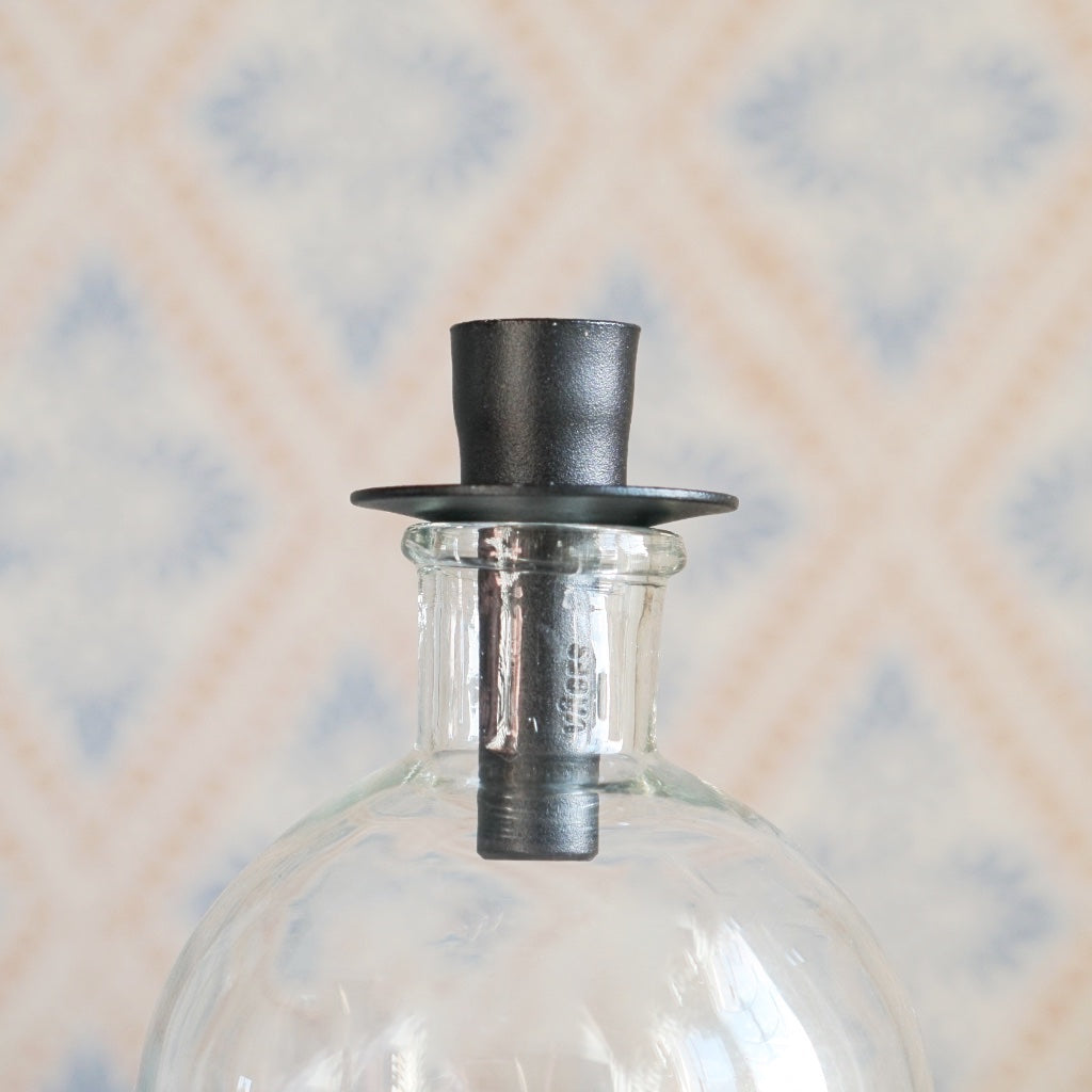 Kerzenhalter für Flaschen in Schwarz auf Glasflasche, Detailaufnahme des Flaschenhalses mit Kerzenhalter