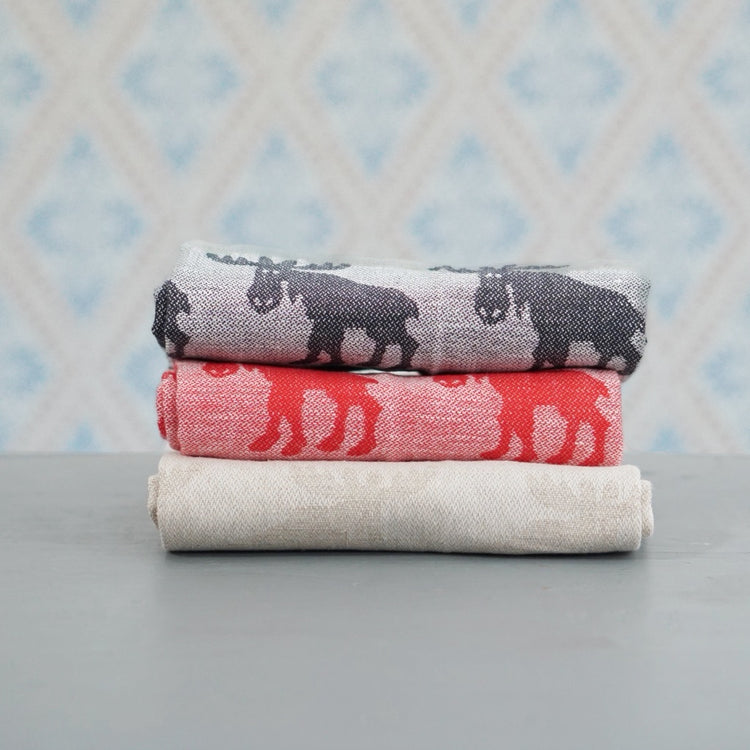 Geschirrtuch mit Elchen aus Halbleinen rot, schwarz, natur im Stapel vor Schwedentapete