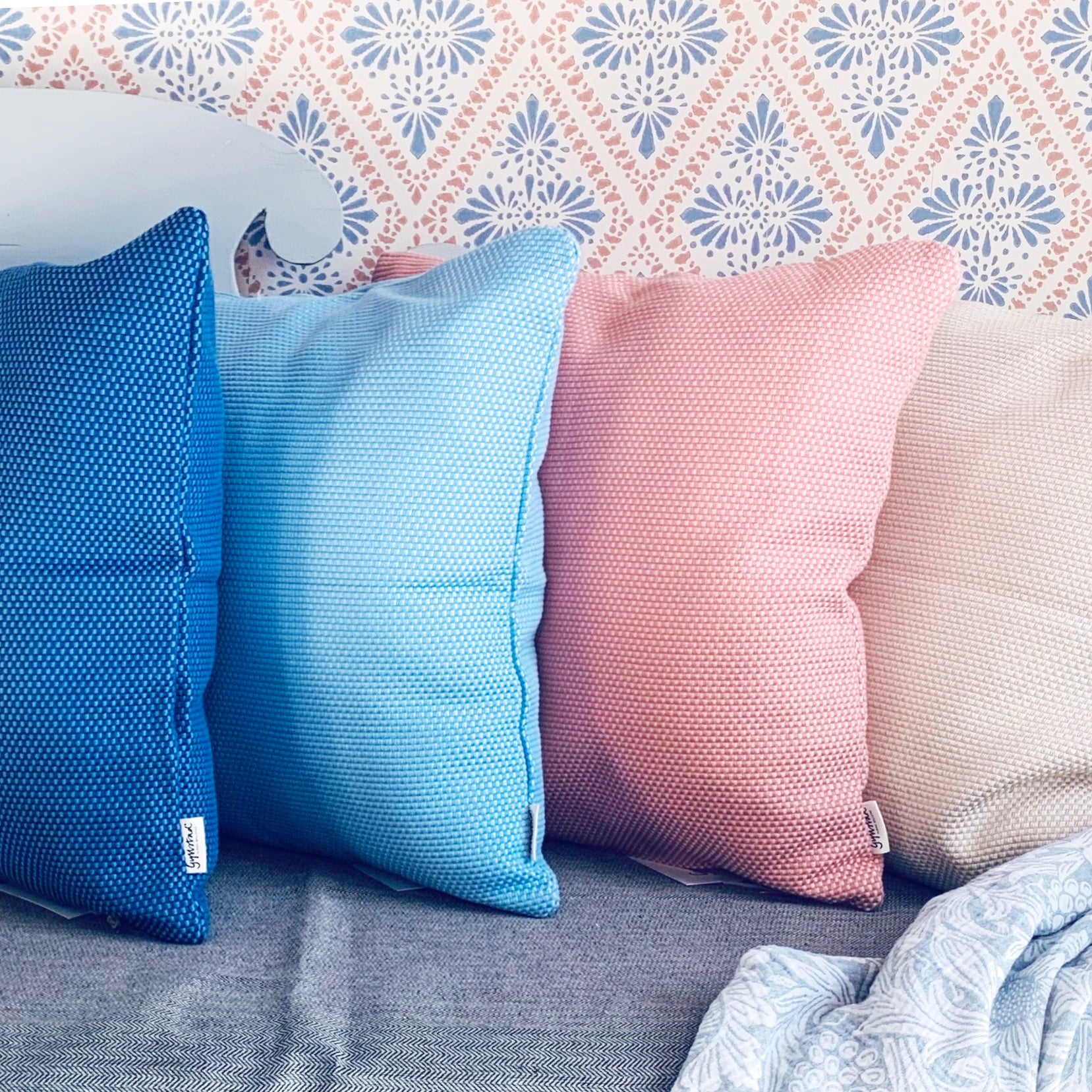 Kissen Heavy Weave in zwei Blautönen, Rosa und Sand auf schwedischem Küchensofa