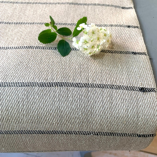 Tischläufer Högbo aus Leinen in schwarz auf Tisch mit Blüte