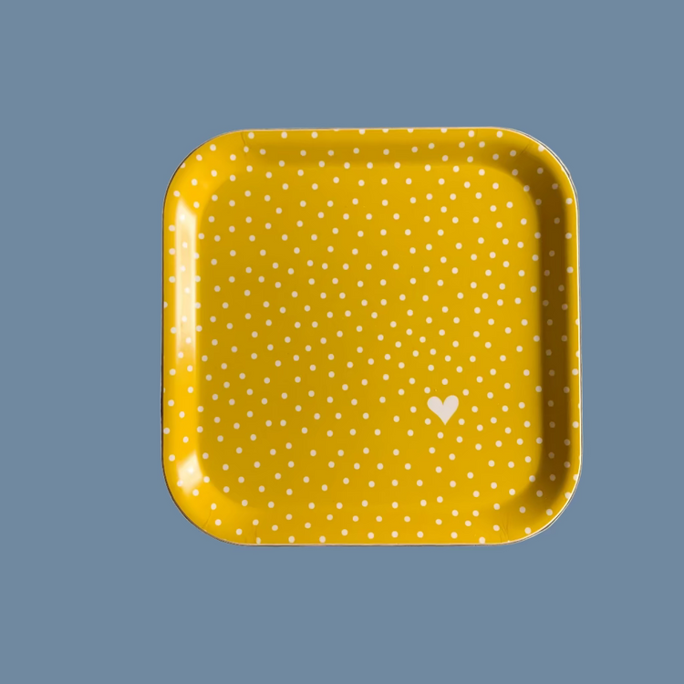 Gelbes, quadratisches Holztablett mit weißen Punkten und einem weißen Herz in der rechten unteren Ecke