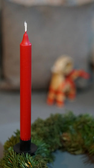 Kerzenhalter für Kranz mir roter Kerze an geünem Kranz im Hintergrund ein julock