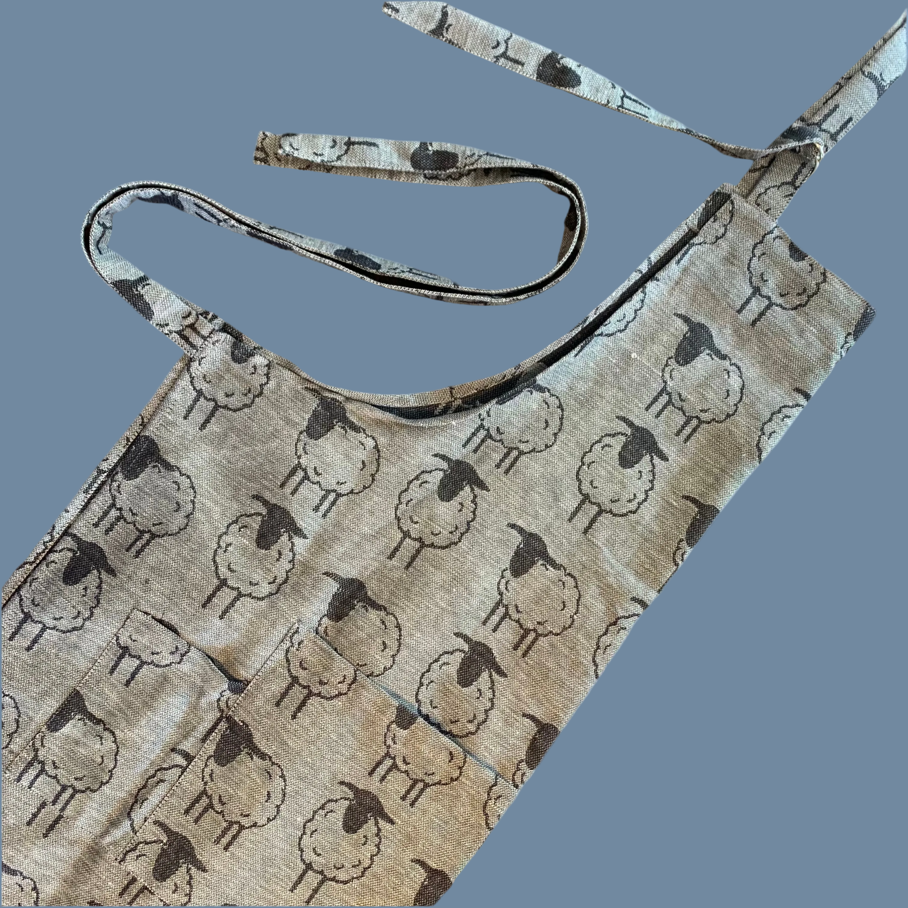 Kochschürze mit Latz und Bändern zum Schließen in grau mit scharz gezeicneten Schafen allover