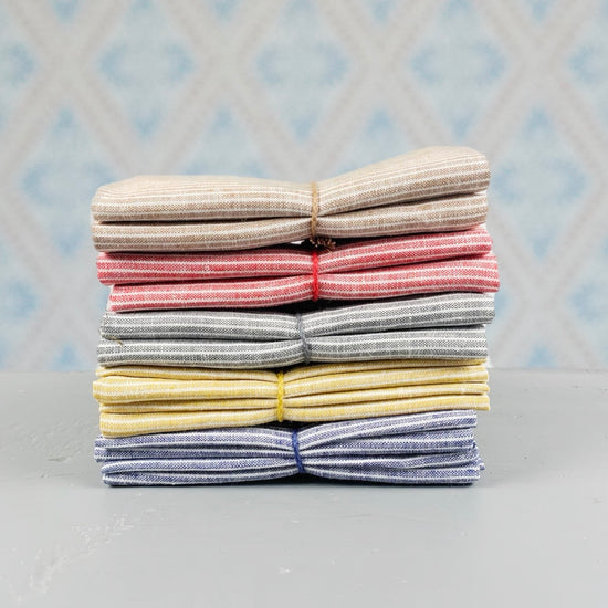 Geschirtuch Kritstreck aus Leinen verschieden Farben im Stapel vor Schwedentapete