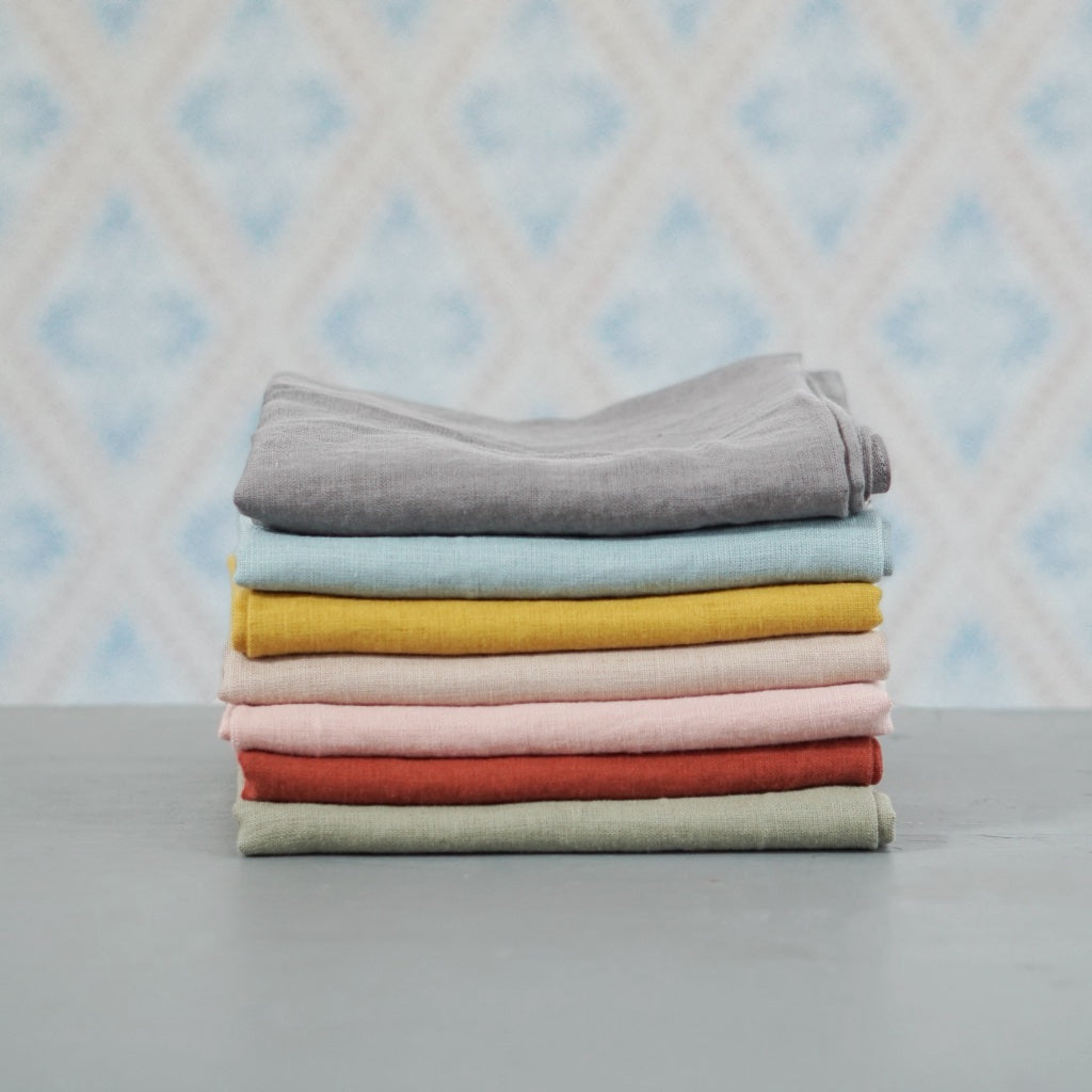Geschirrtuch Linn aus Leinen in verschiedenen Farben im Stapel vor Schwedentapete