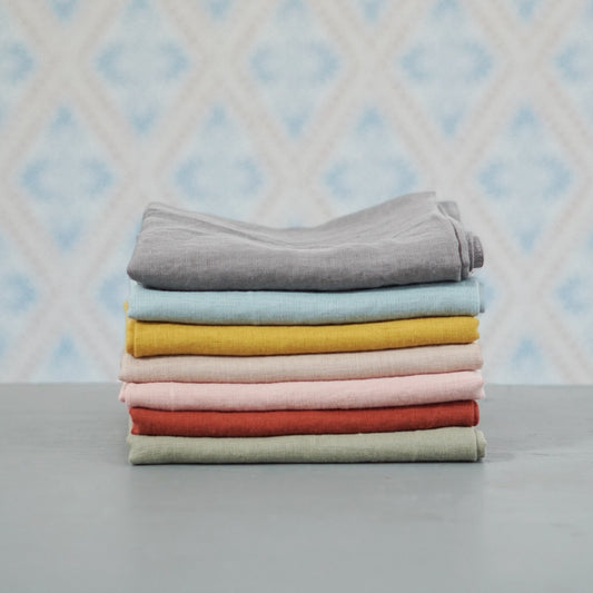 Geschirrtuch Linn aus Leinen in verschiedenen Farben im Stapel vor Schwedentapete