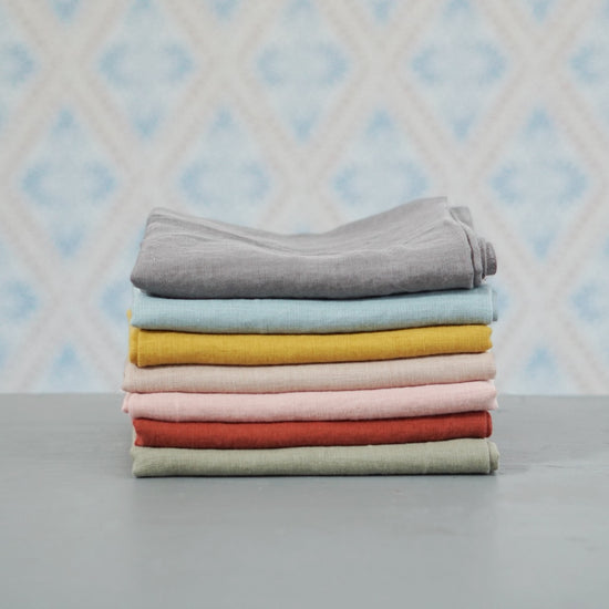 Geschirrtuch Linn aus Leinen in verschiedenen Farben im Stapel vor Schwedentapete