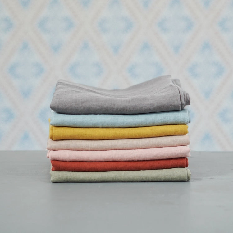 Geschirrtuch Linn aus Leinen in verschiedenen Farben im Stapel vor Schwedentapete