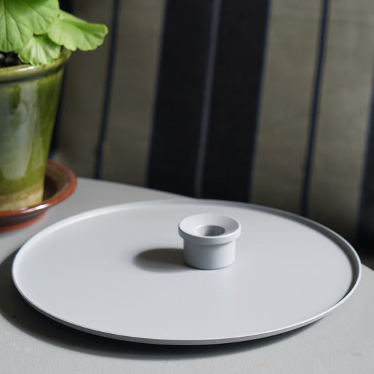Kerzenteller und Kerzenhslter auf Tisch mit Pelargonie