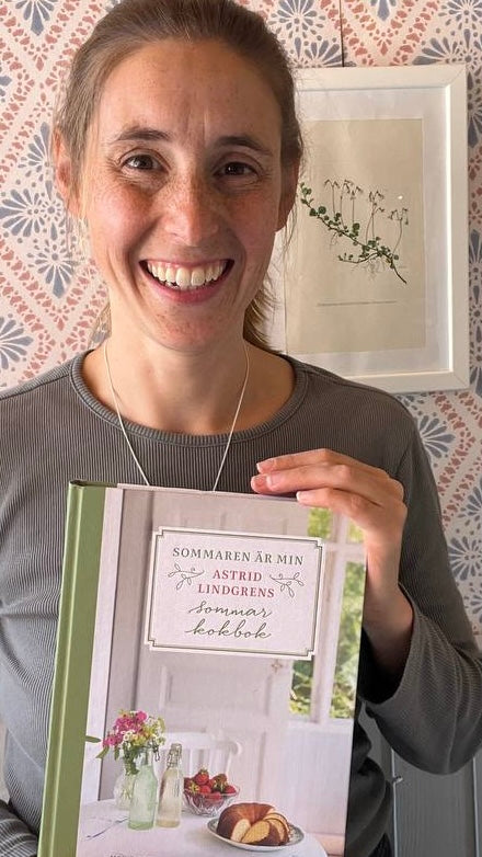 Marie hält das Astrid indgren Kochbuch in der Hand