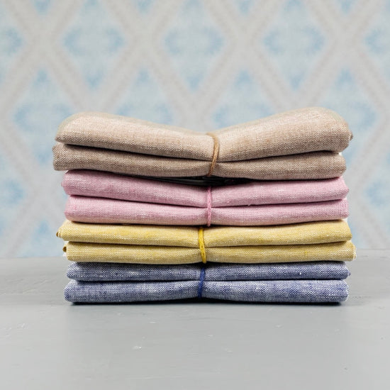 Geschirrtuch Meliert aus Leinen im Stapel mit verschiedenen Farben vor Schwedentapete