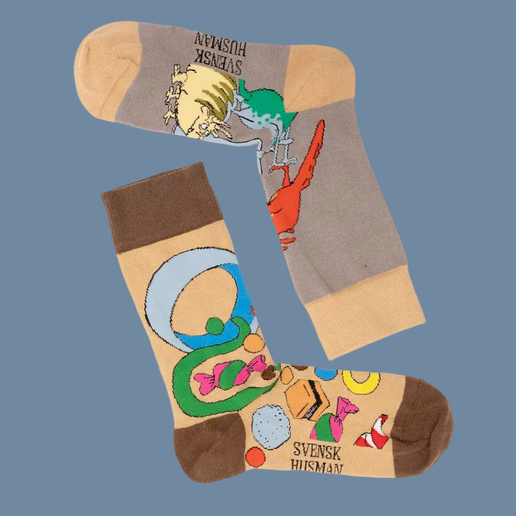 andere Seite der Hellbraunen Socke mit brauner Ferse, Spitze, Bündchen und bunten Mucklas samt Süßi, und andere Seite der grauen Socke mit hellbraunem Bündchen, Spitze, Ferse und Mucklas mit Pilzen