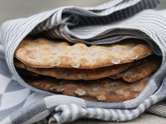 rundes Knäckebrot eingeschlagen mit Serviette Schackrutan in grau