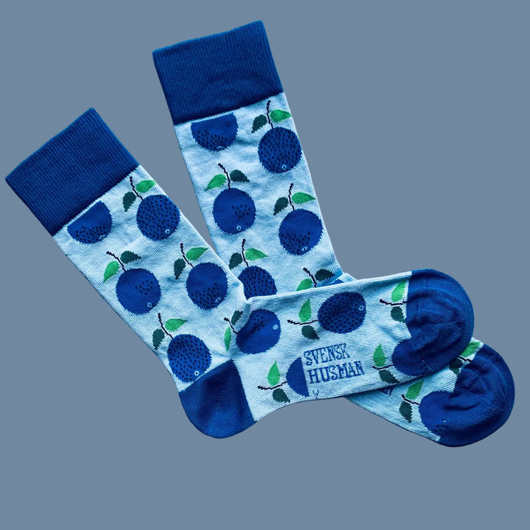 Hellblaue Socken Prunus mit Pflaumen und dunkelblauer Ferse und Spitze vor mysblauem Hintergrund