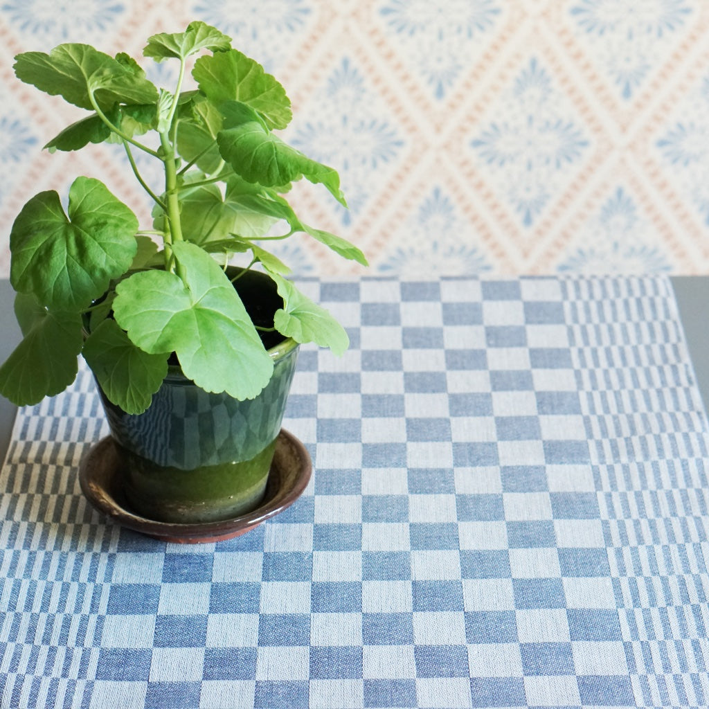 karierter Tischläufer auf Tisch mit Pelargonie