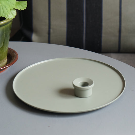 Set Kerzenteller und Kerzenhalter in Farbe wiese auf grauem Tisch mit Pelargonie