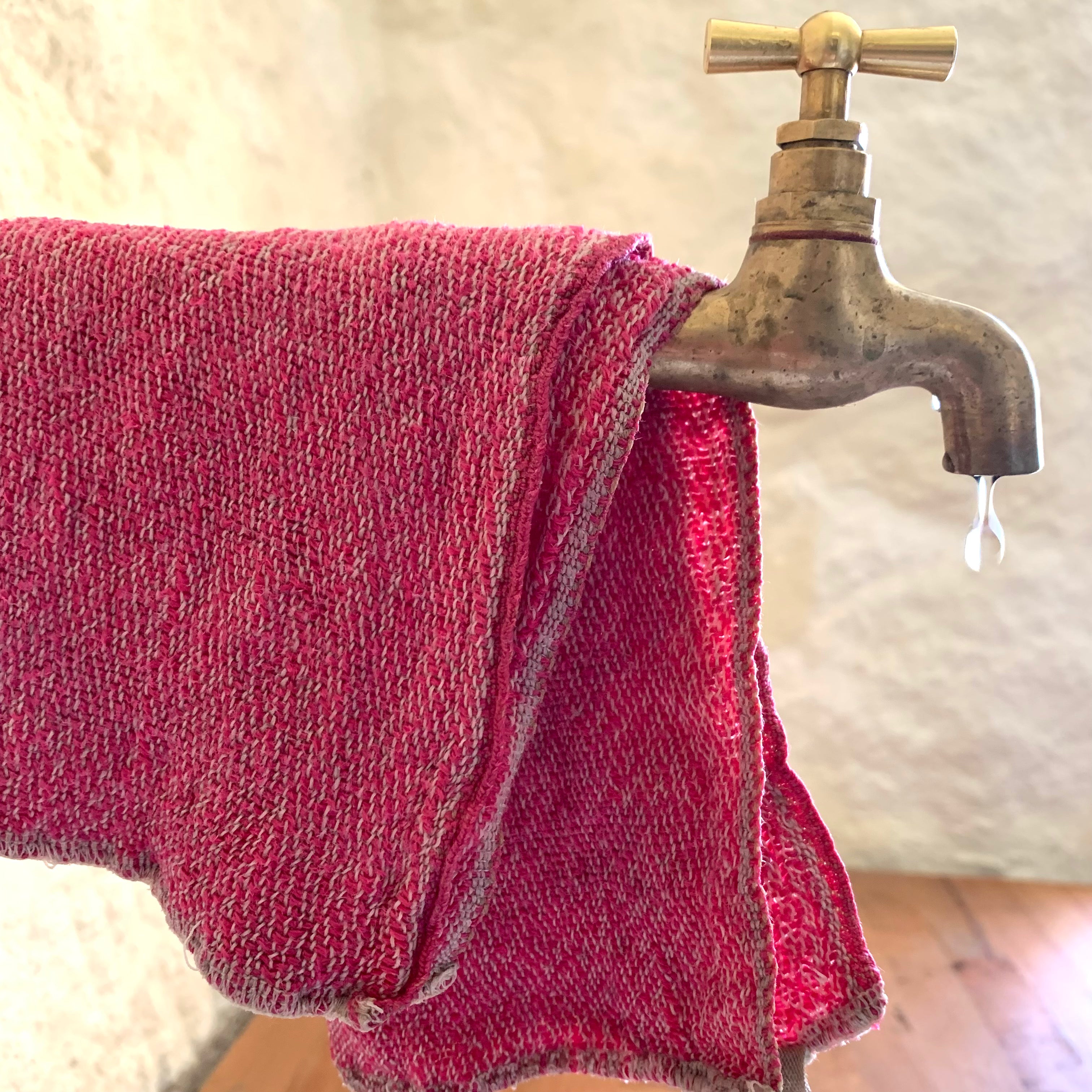 Spültuch cerise aus Leinen ber Wasserhahn mit Wassertropfen
