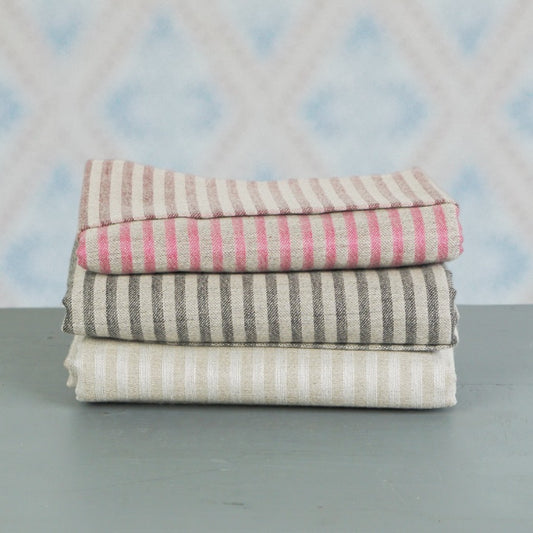 Badetuch Storm aus Leinen gestapelt vor Schwedentapete