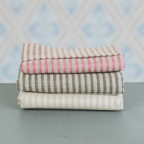 Badetuch Storm aus Leinen gestapelt vor Schwedentapete