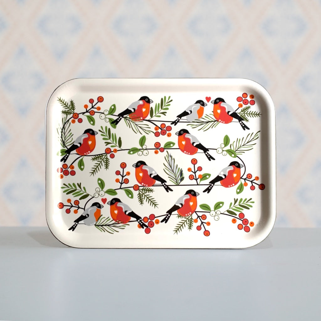 rechteckiges Holztablett mit Dompfaffen stehend vor Wand mt tyisch schwedischer Tapete