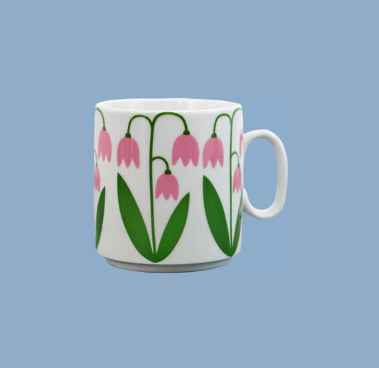 Tasse aus weißem Porzellan mit Linneapflanzen